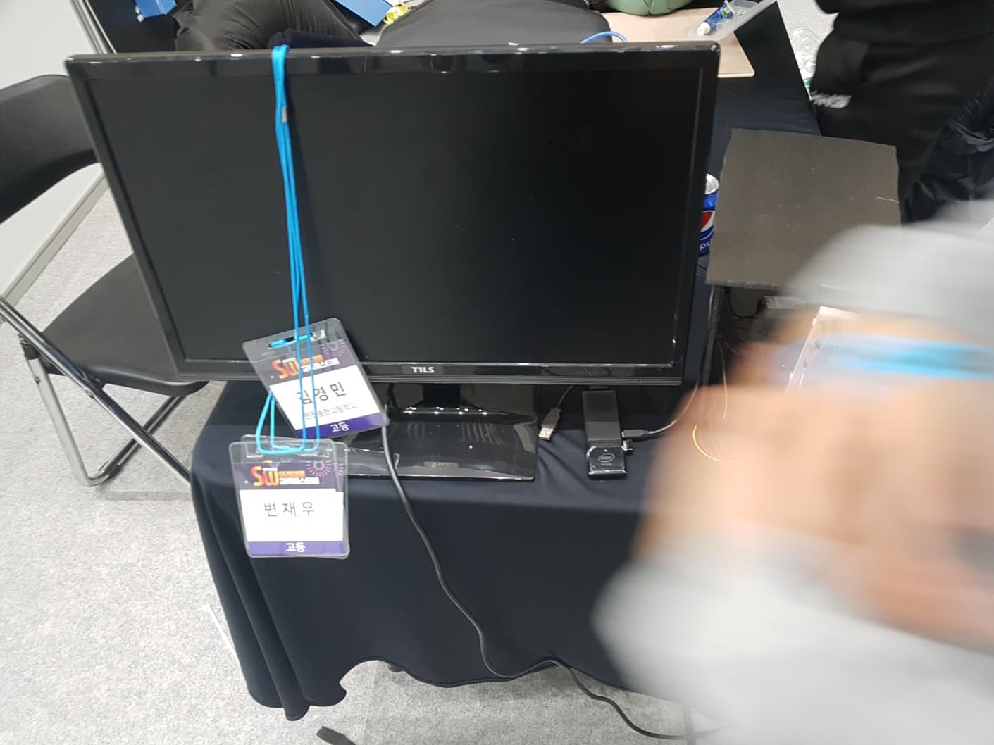 고등학생 시절 SW해커톤 참가 부스. 모니터와 명찰이 보임