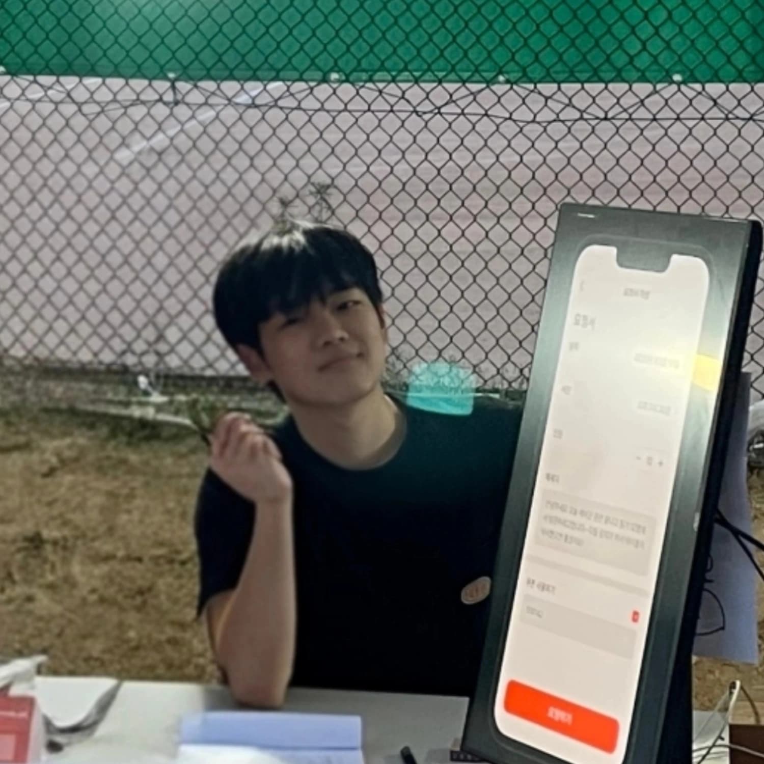 야외 파일럿 부스에서 개발한 앱 시연 화면 옆에 앉아 있는 모습